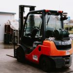 Close-up of a parked Toyota forklift at an industrial site, showcasing utility and machinery.