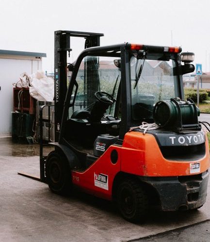 Close-up of a parked Toyota forklift at an industrial site, showcasing utility and machinery.